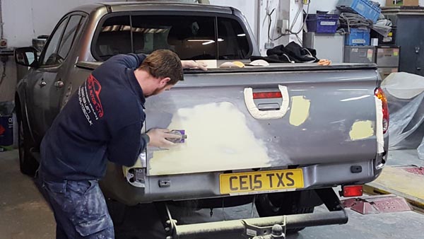 Technician repairing a pickup tailgate